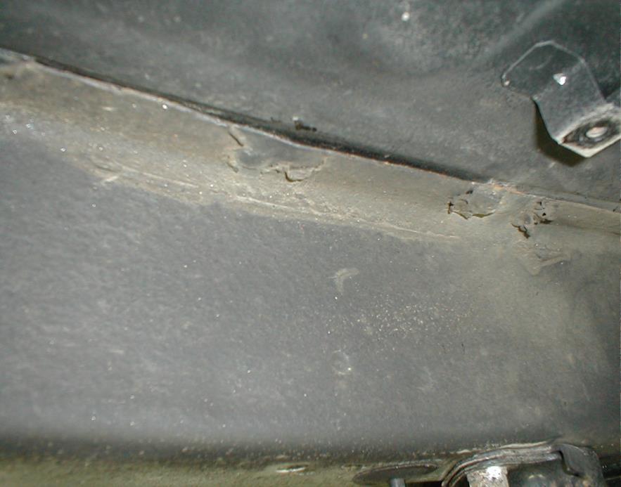 Arrow points to top-side of trunk floor where frame rail is welded to underside Poor quality and insufficient welds