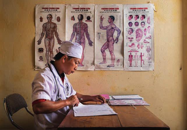Dr. Chang As Xinh, 37, updates records in his office at a community hospital in northeast Vietnam. Dr.