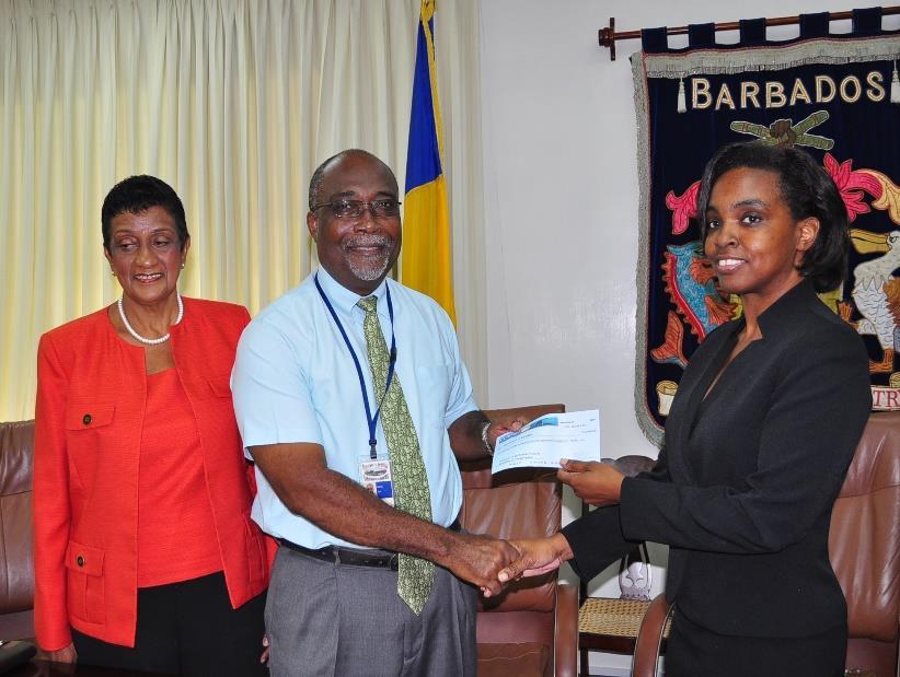 CCRIF Polices Mr. Martin Cox, Director of Finance and Economic Affairs receives a cheque for US$1.28M from CCRIF Board Member Mrs. Faye Hardy at a ceremony on December 8, 2014.