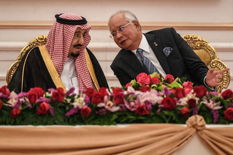 Malaysia's Prime Minister Najib Razak (R) talks with Saudi Arabia's King Salman (L) during the signing of a memorandum of understanding between the two countries in Putrajaya, outside Kuala Lumpur on