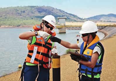 Image Environmental engineers Hamanda Jansen (left) and Anita Marques take water-height readings at the dam at Barro Alto mine.