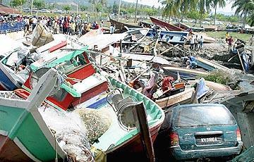 Fisherman boats and cars were pushed by the tidal wave and left stranded at Kuala