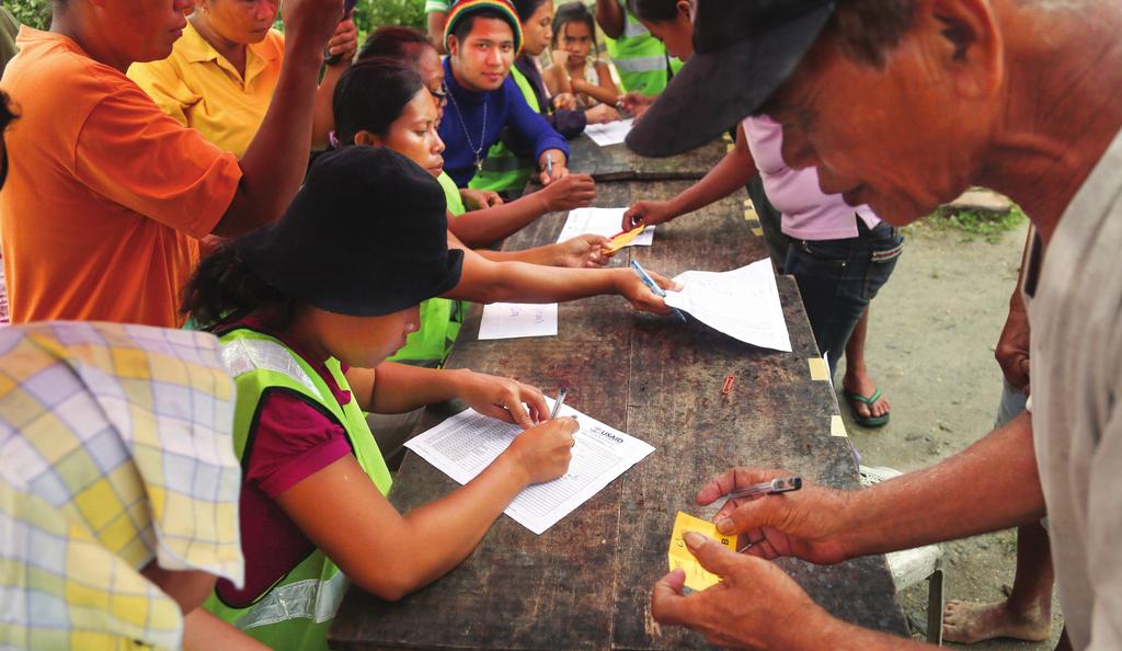 CASE STUDY Maria Janice Boholst and other volunteers register beneficiaries to receive a CRS emergency shelter at a distribution site in the village of Esperanza, outside Ormoc City.